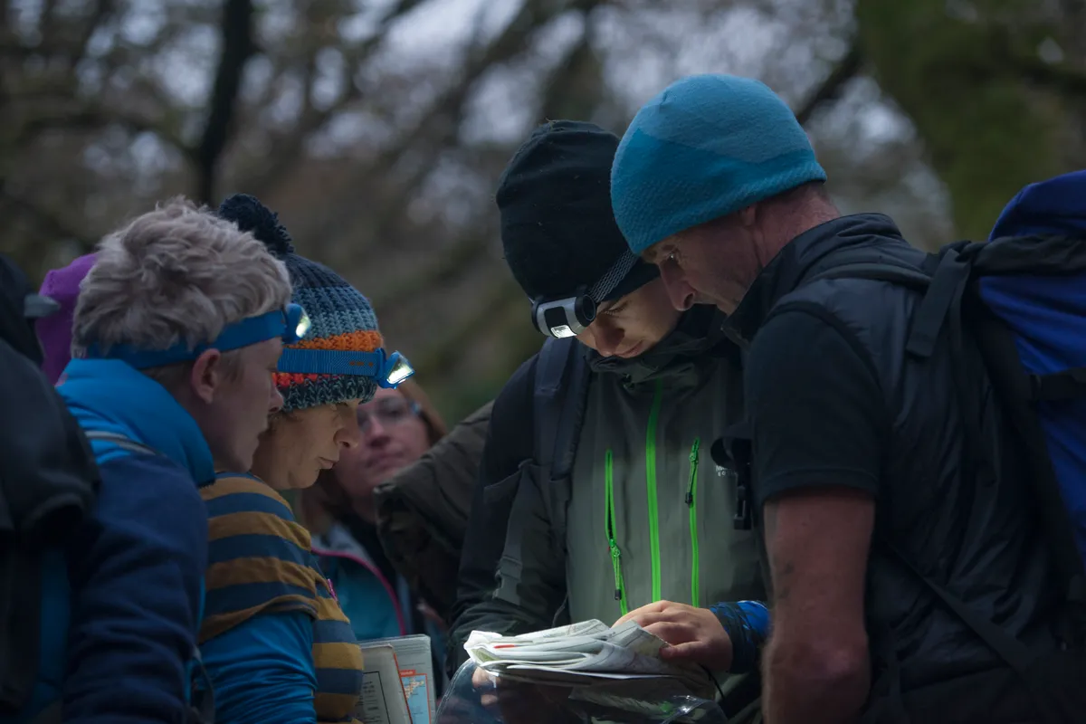Group of people studying map, orienteering