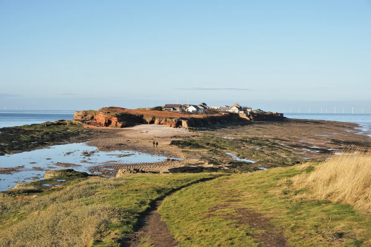 Looking towards Hilbre Island with blue sky and beach