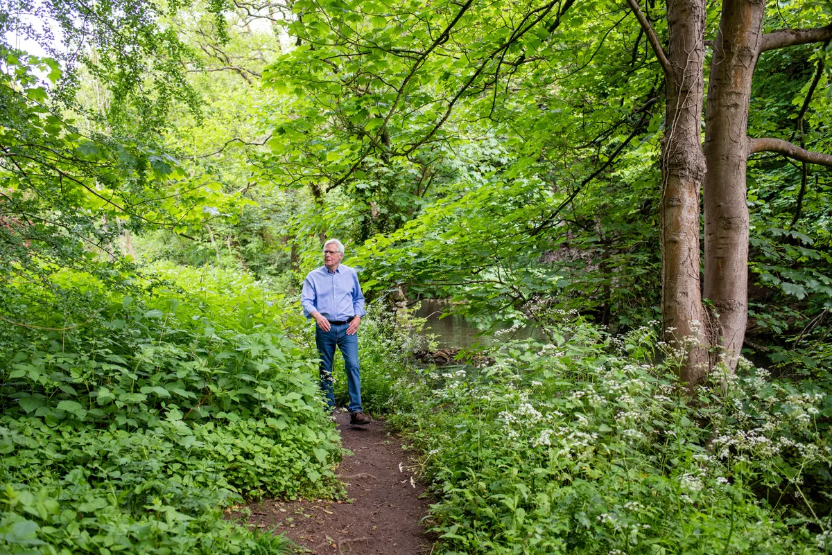 John Craven walking through the park in Bristol