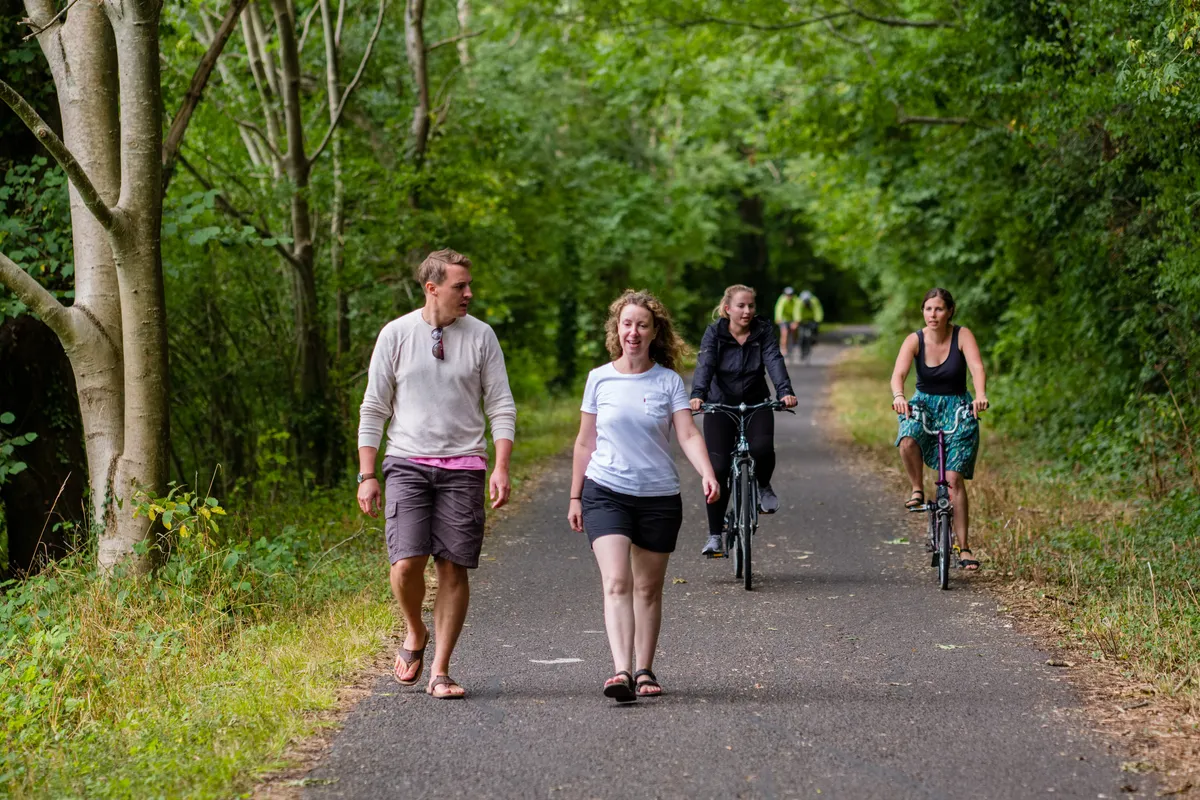 Walkers and cyclists enjoying traffic-free path through woodland (National Route 4, Bristol and Bath Railway Path, Severn and Thames).