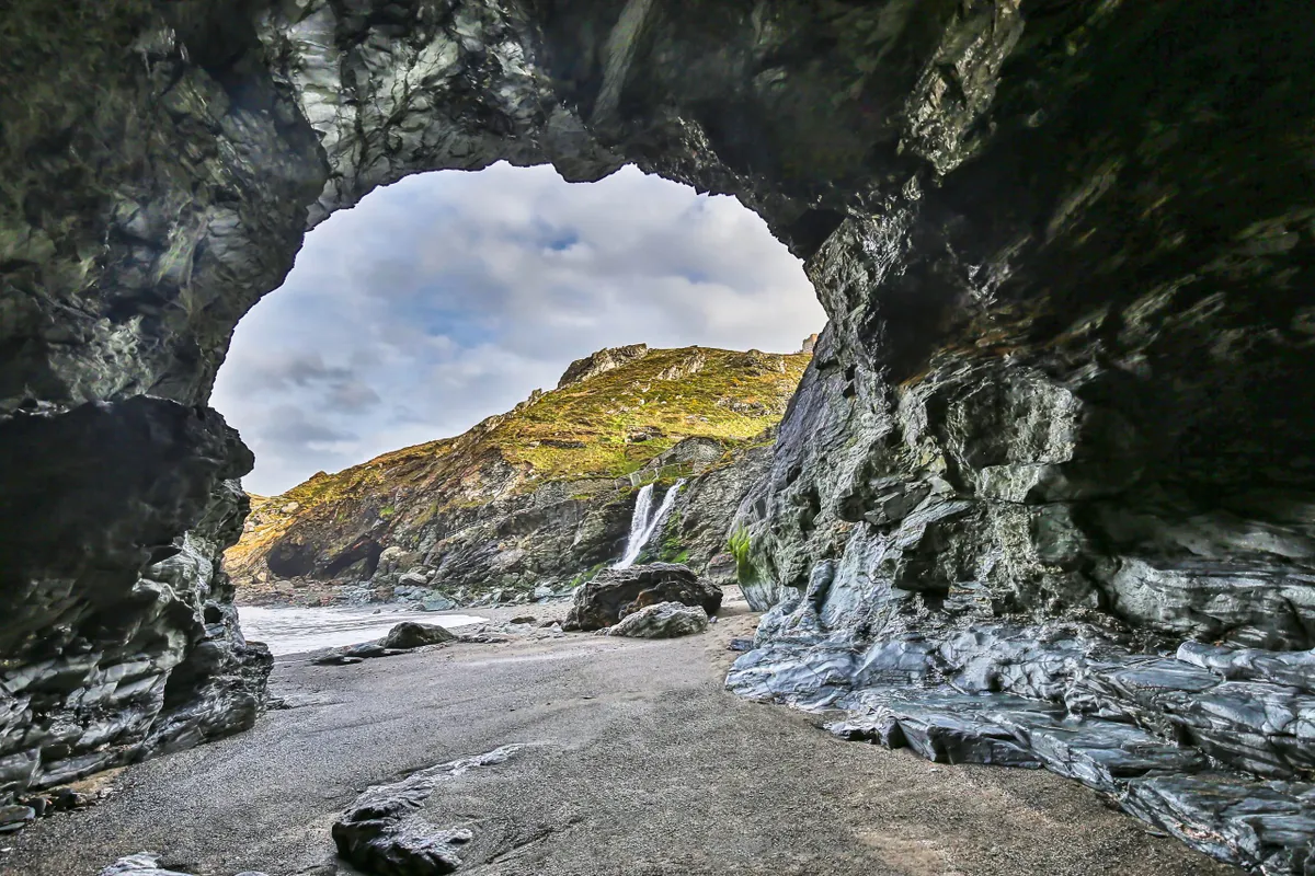 Merlins Cave sits beneath Tintagel Castle in Cornwall