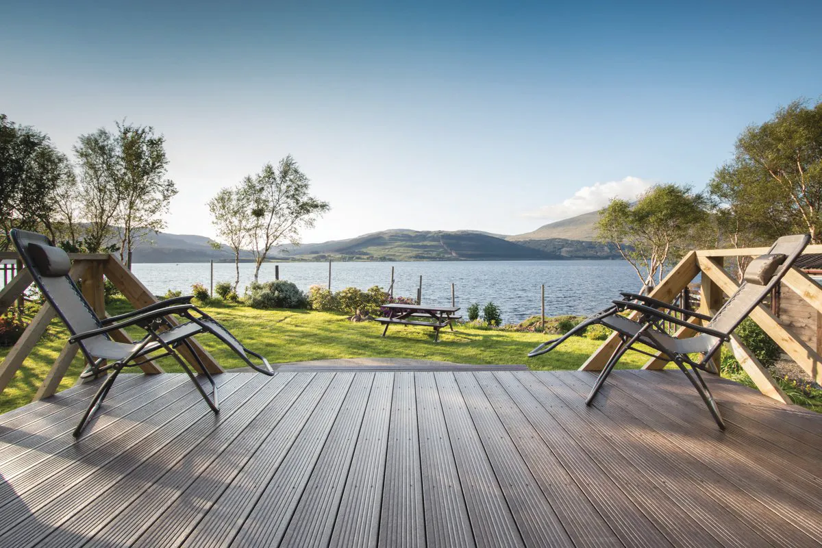 Deckchairs on decking overlooking a lake