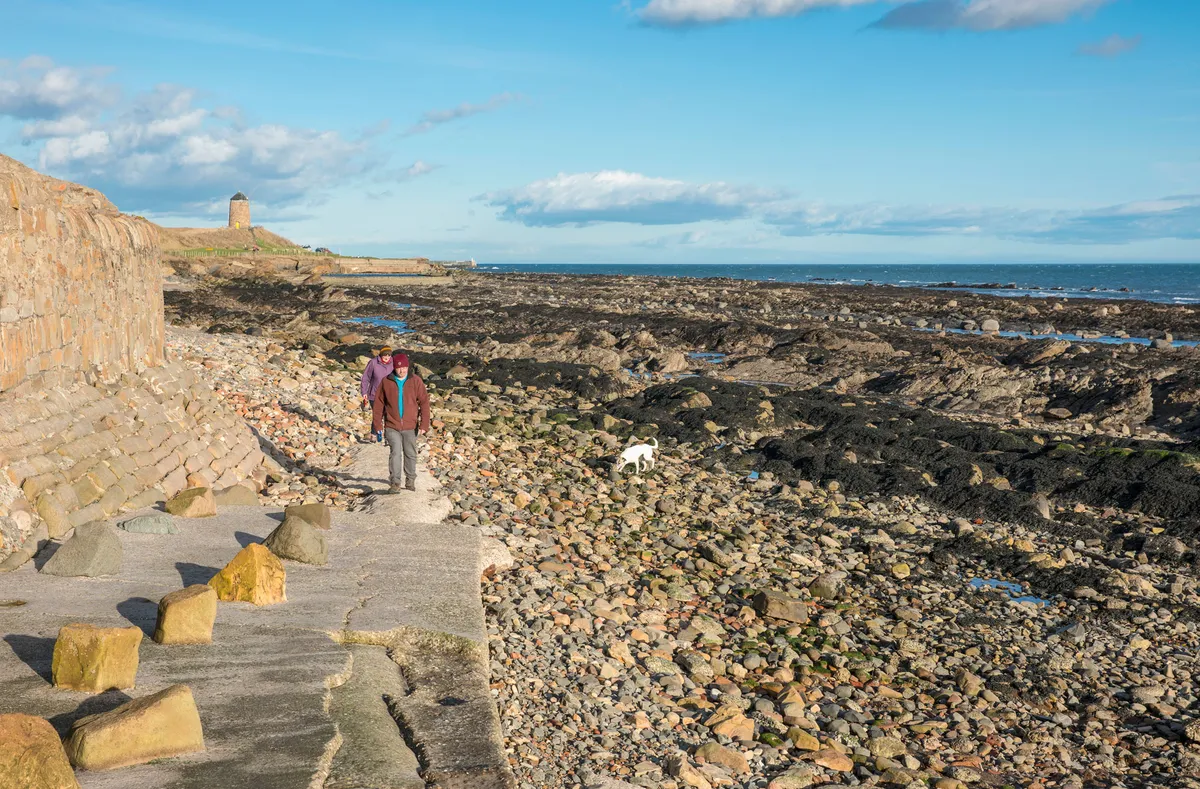 Walkers on the beach near the Fife Coastal Path/Credit: Kenny Lam, VisitScotland