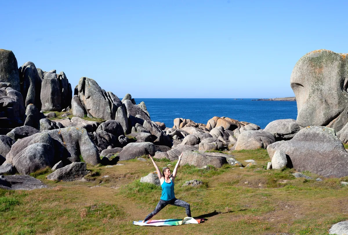 Woman doing yoga by the sea