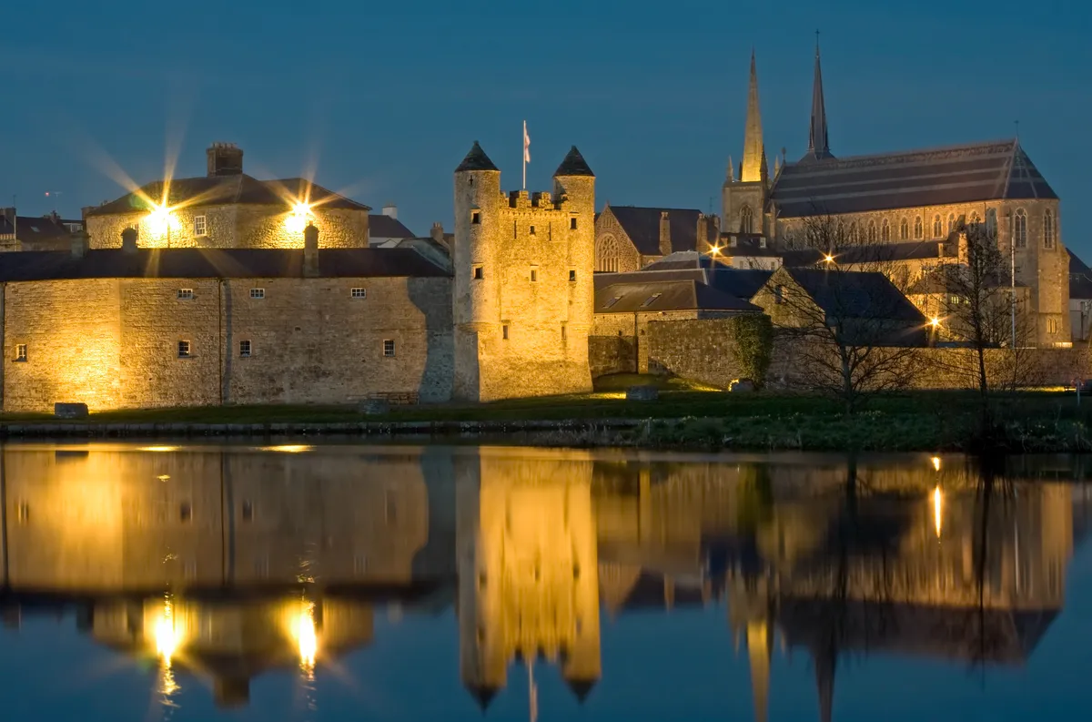 Town and castle on river at dusk