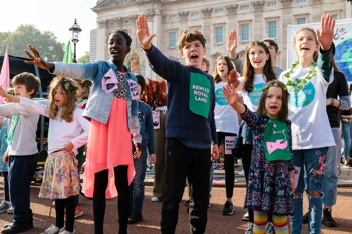 Children's choir SOS serenade the crowd outside Buckingham Palace