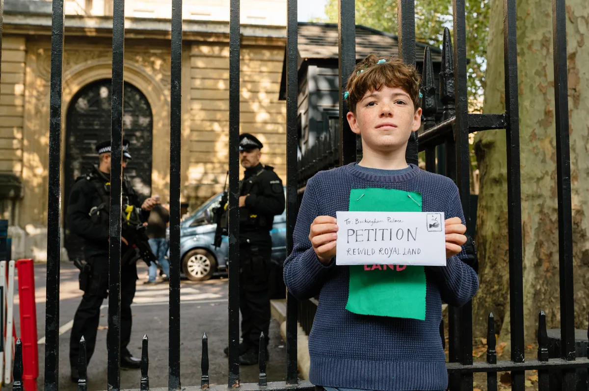 A teenage boy holding an envelope addressed to the Royal Family