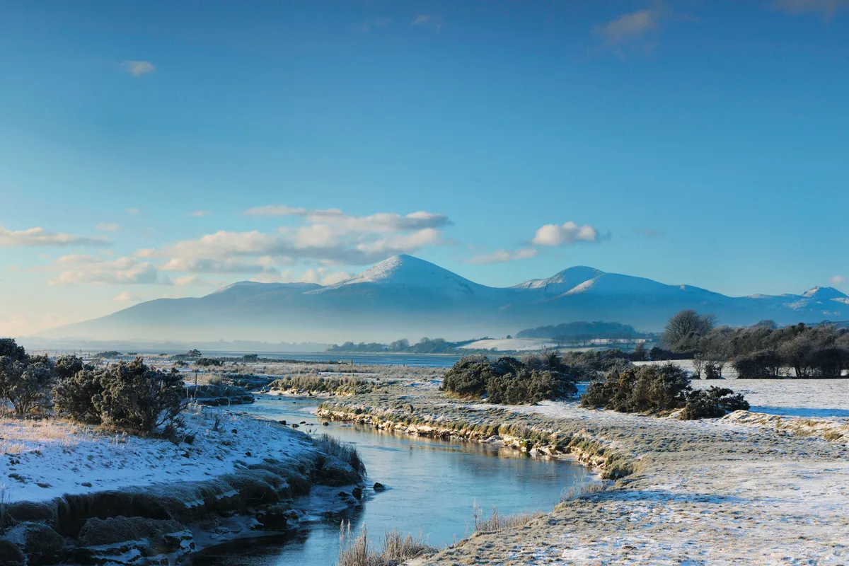 Snowy river and coastline and mountains