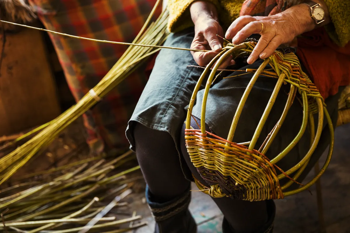 Close up of woman weaving a basket in weavers workshop