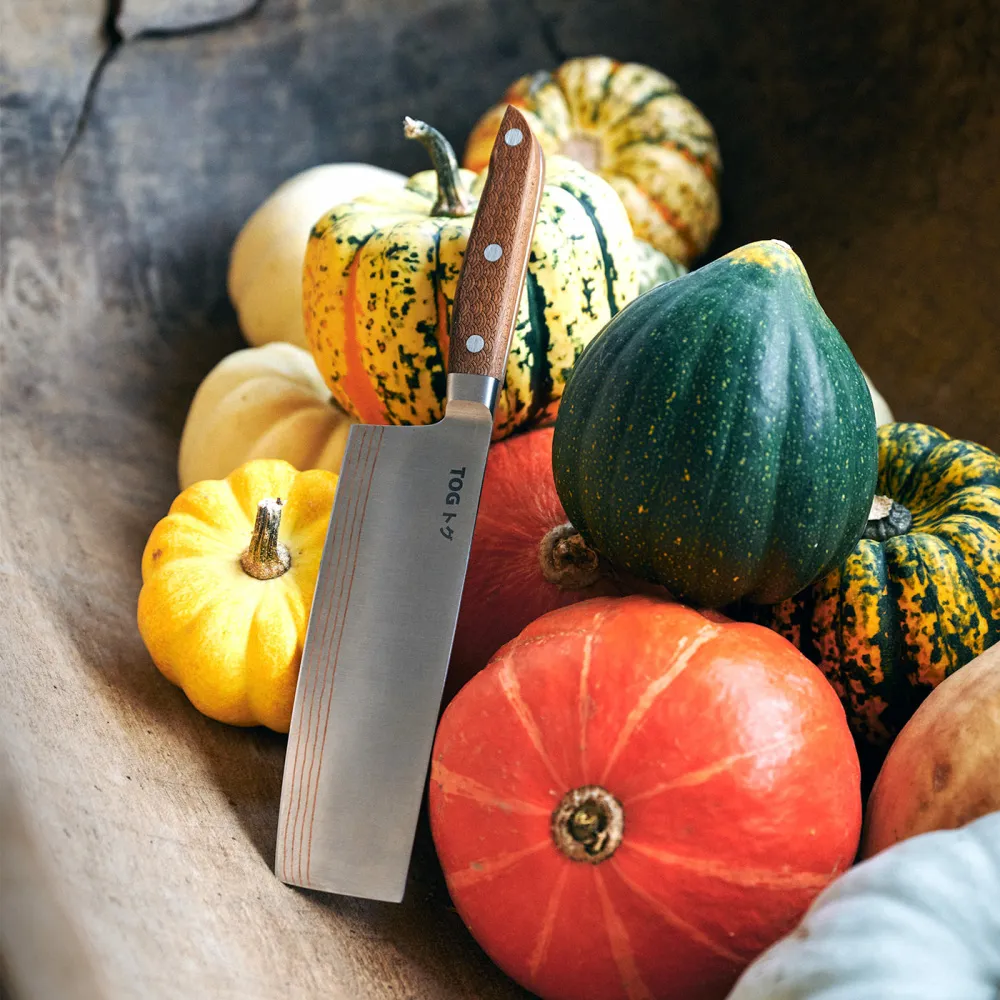 A Japanese knife in front and some colourful pumpkins