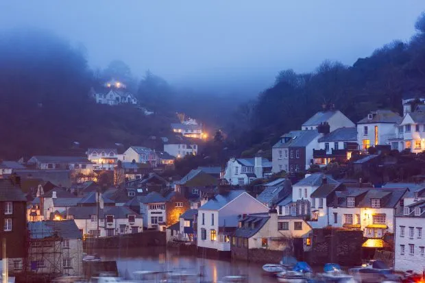 Coastal fishing village harbour at night in mist