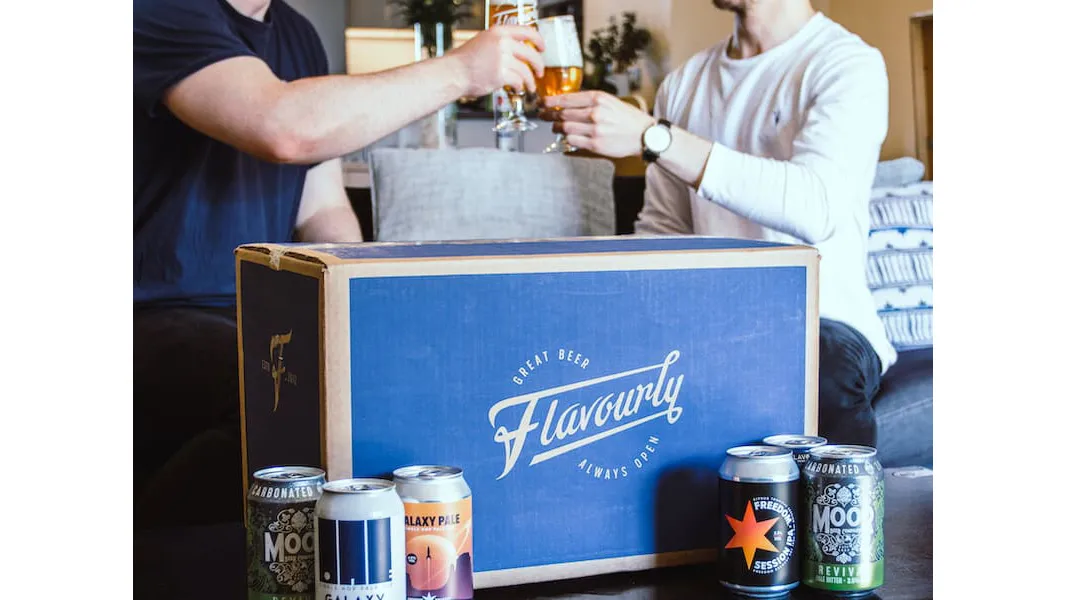 Flavourly Beer Club box with beers and people drinking in the background