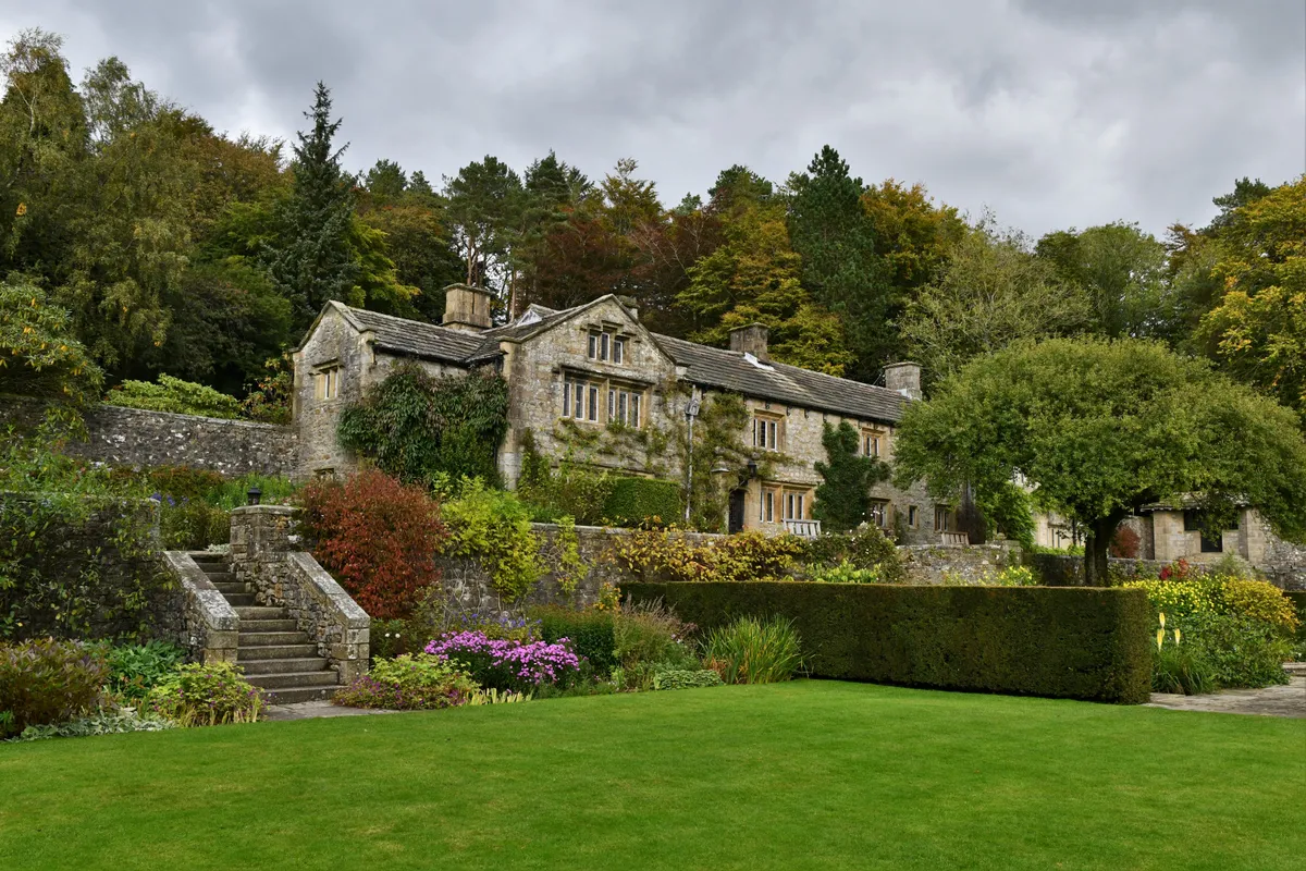Parcevall Hall Gardens in flower with trees and house behind