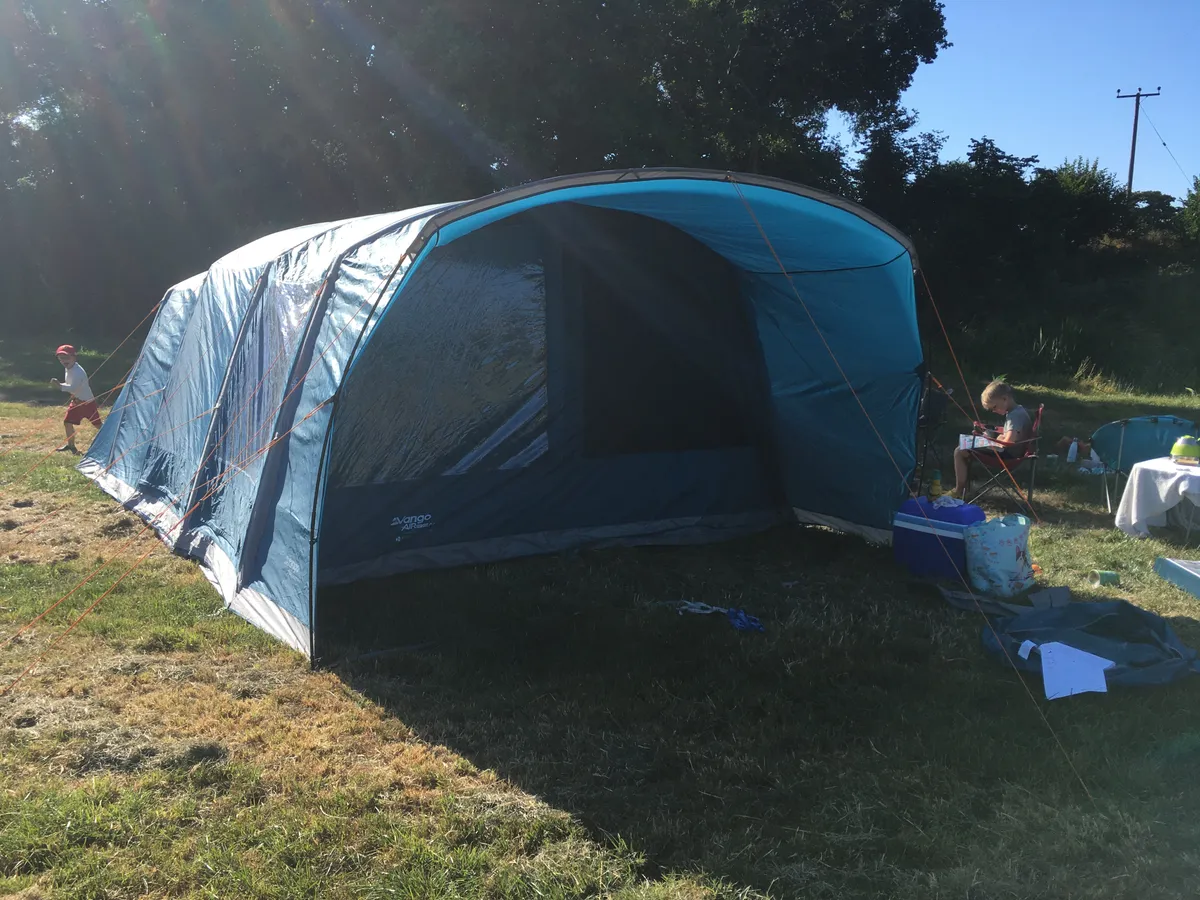 Blue Vango tent in sunshine in field viewed from front
