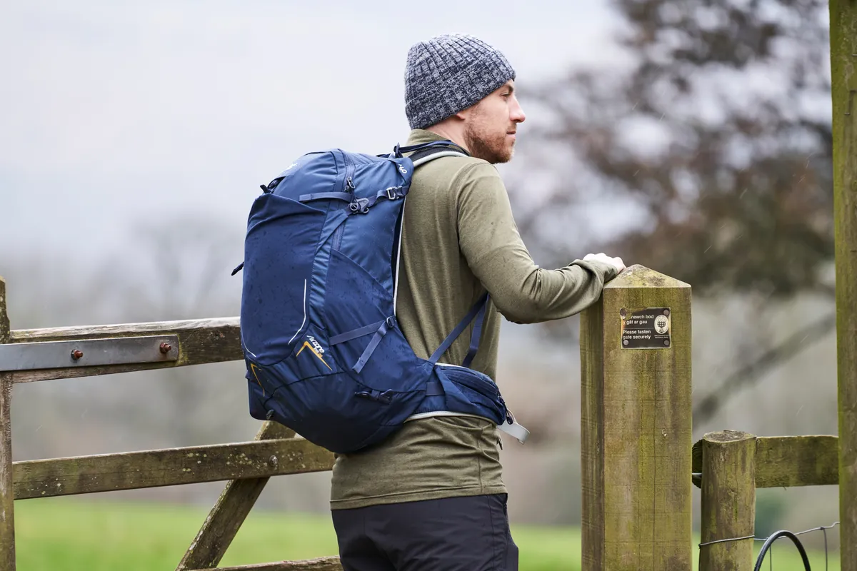 Man wearing Lowe Alpine AirZone Trek 28L backpack in the countryside