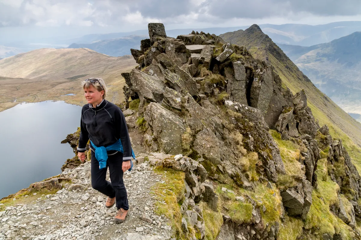 Mature woman hiker on Striding Edge and Helvellyn in the Lake District National Park