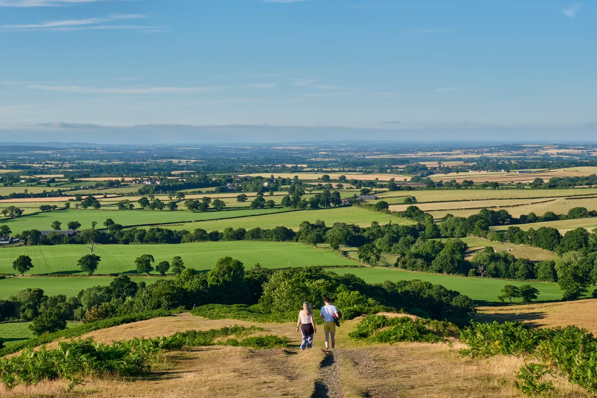 Walkers descending The Lawley (overlooking North Shropshire) near Church Stretton in Shropshire
