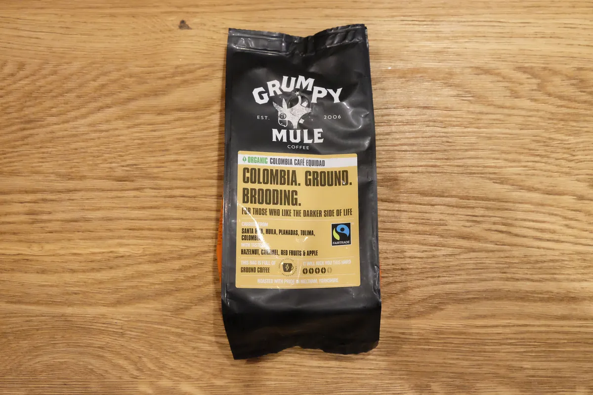 Grumpy Mule Colombia Organic Ground Coffee on a wooden table