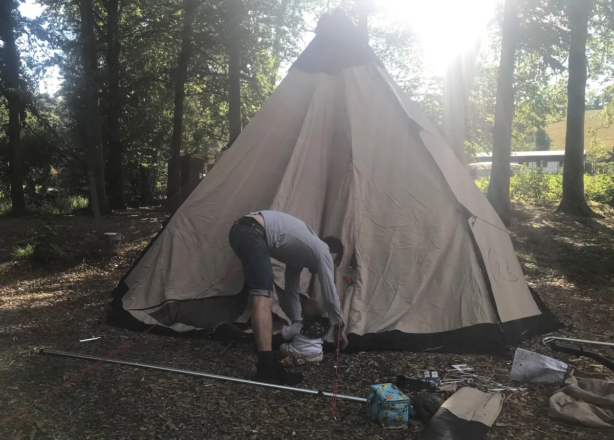Tipi tent being put up by man