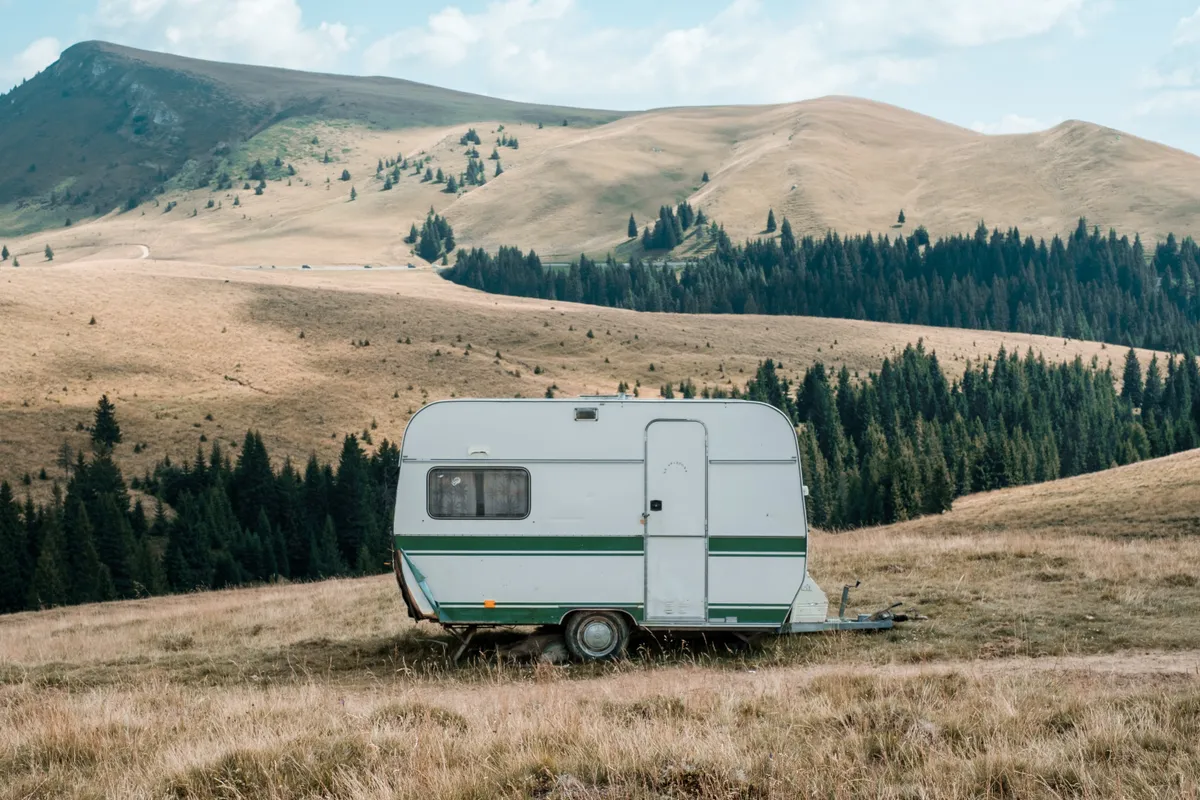 White and green caravan in mountains