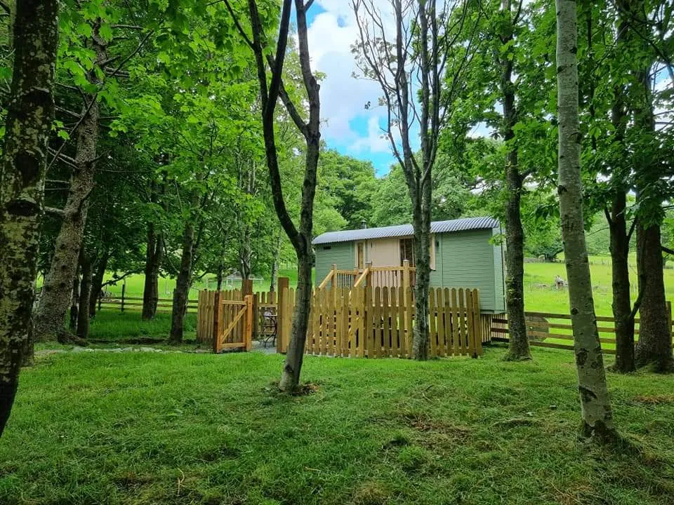Shepherd's hut among trees at Sykefarm Campsite in the Lake District