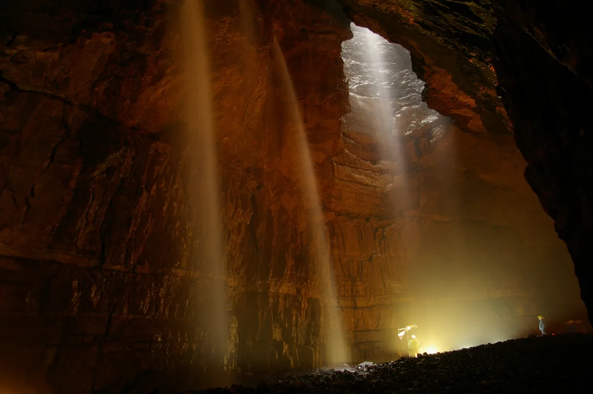Shafts of light in the huge cavern of Gaping Gill in Yorkshire