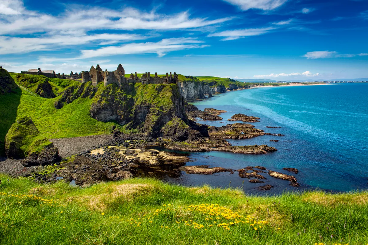 Dunluce Medieval Castle on the north Coast of Northern Ireland with blue sea and green cliffs
