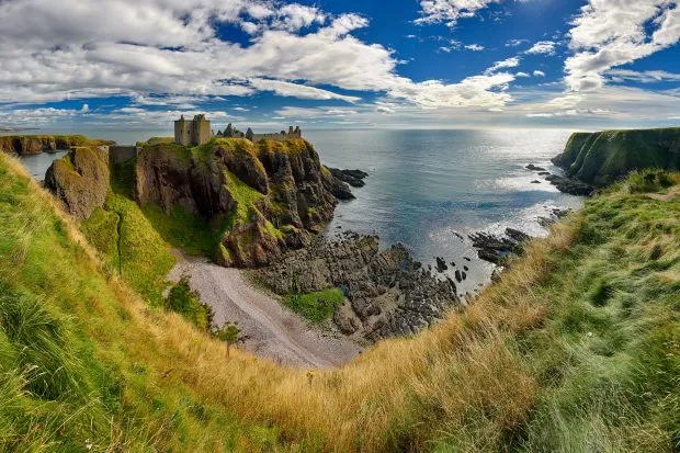 Medieval fortress of Dunnottar Castle with cloudy sky and sea