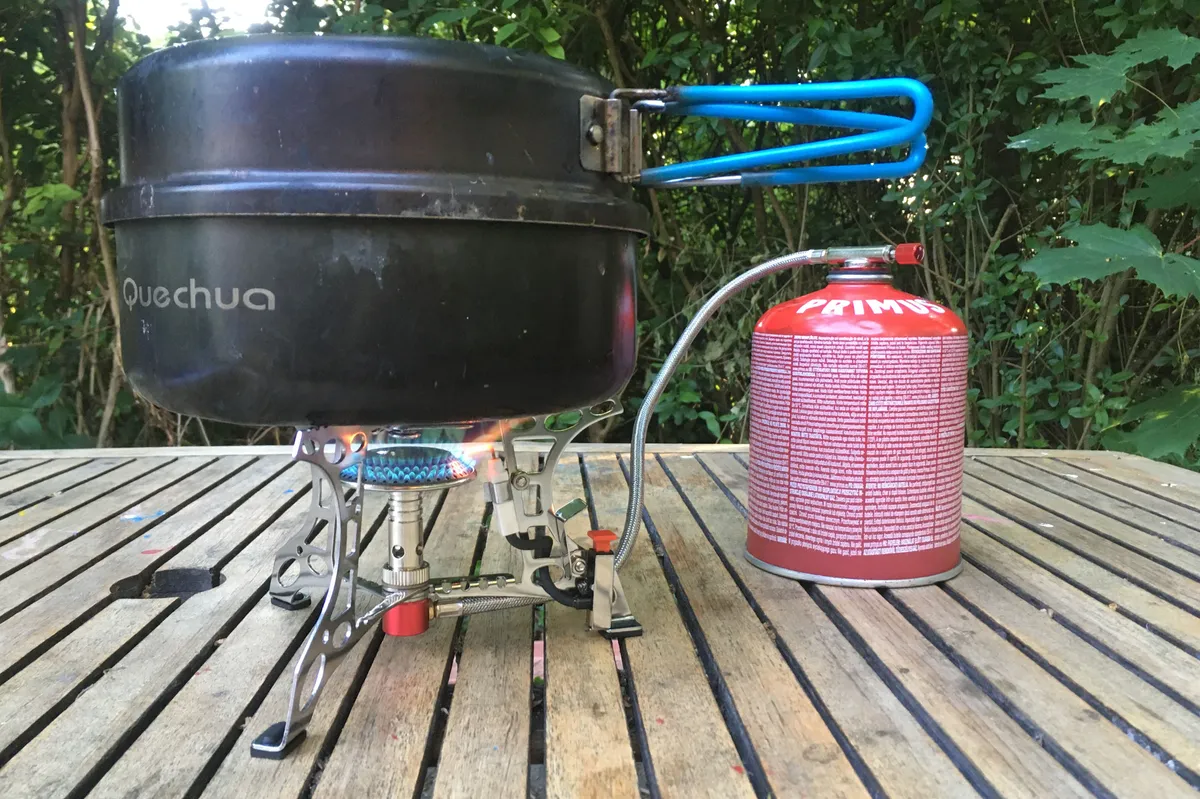 Highlander Triplex camping stove on a wooden table