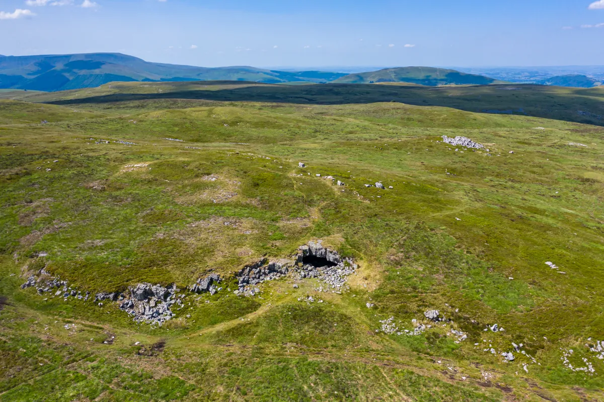 Aerial view of the entrance to an underground cave system on remote moorland