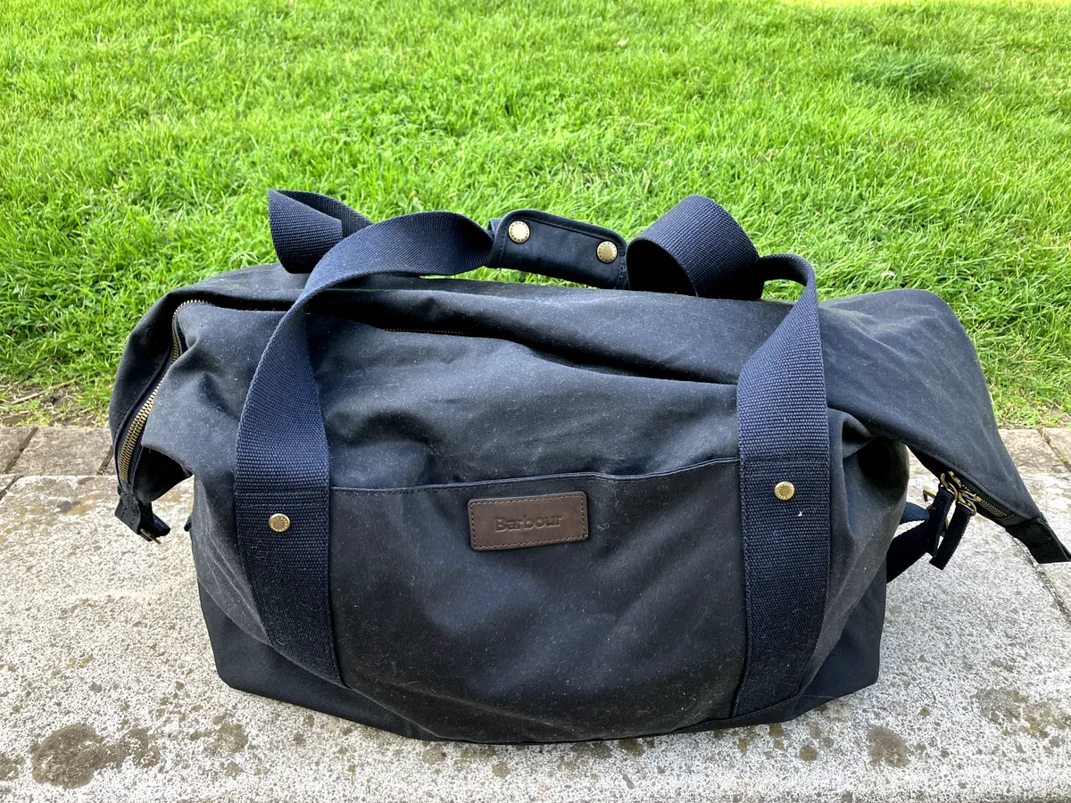 Barbour Essential Waxed Cotton Holdall on a paving stone
