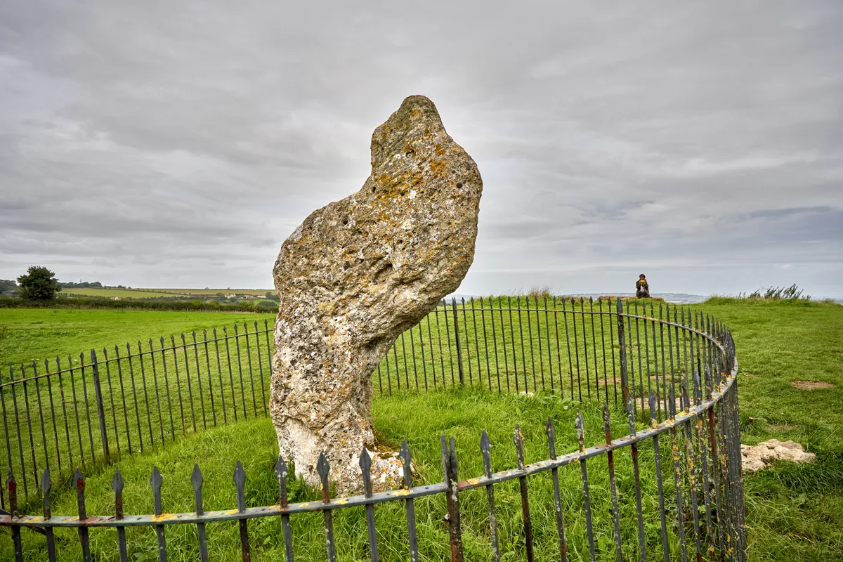 A woman in the distance taking a picture of the King Stone