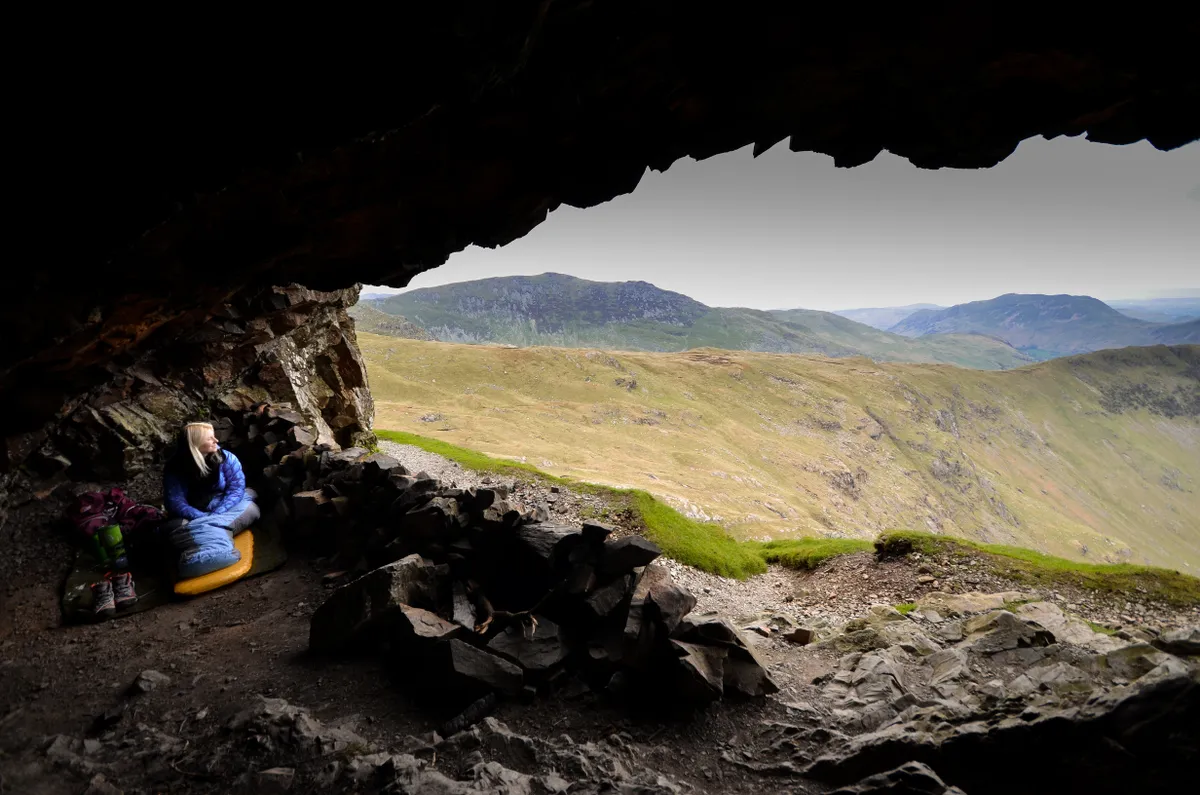 Camping in Priests Hole Cave with mountains and hills beyond