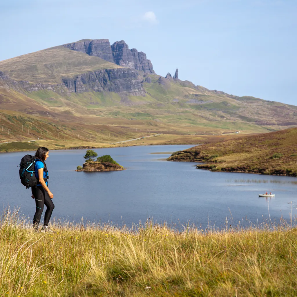 Woman walking at Loch Fada and the Old Man of Storr