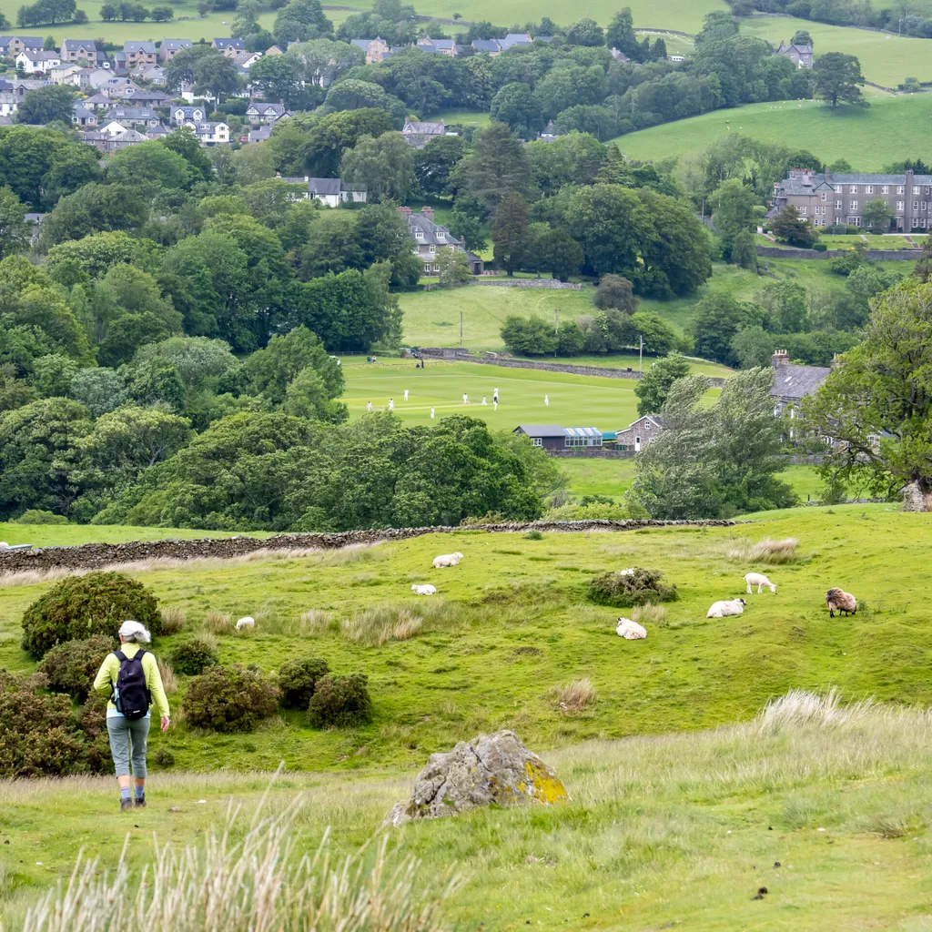 Looking down to Sedburgh with a woman on the Dales Way in the Yorkshire Dales National Park