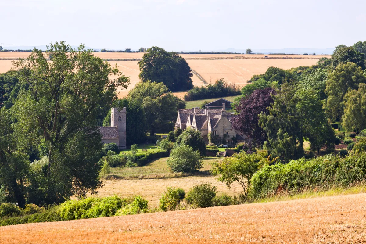 Asthall Manor and village church nestled in the Cotswold countryside