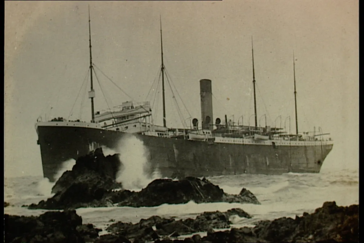 Black and white photo of the vessel against the rocks