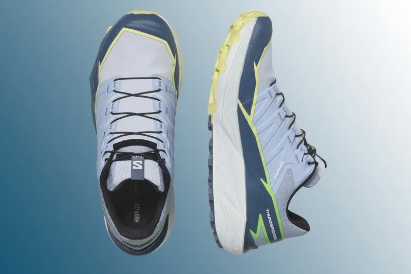 Pair of trail running shoes on blue background 