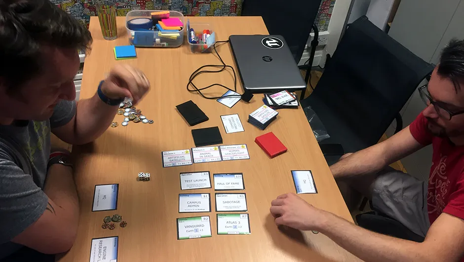 Auroch Digital's Tomas Rawlings (left) and Steve Martin (right) play a card game version of Mars Horizon in their Bristol studio. Reinterpreting the game in this way helps developers experiment with gameplay and test out new ideas.