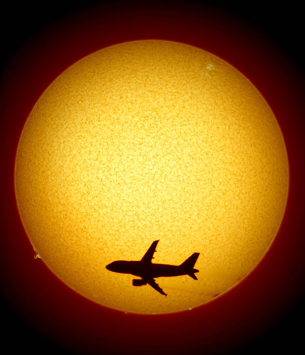 Photobombed by a plane: Sol by David Pickles, Rushden, UK. Equipment: Altair GPCAM 290M, 0.5x focal reducer, Lunt LS50Tha 600B PT solar scope.