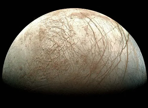 Europa viewed from NASA’s Galileo spacecraft. Note the bright ice, huge cracks and dark patches that probably contain both ice and dirt Image: NASA/Ted Stryk