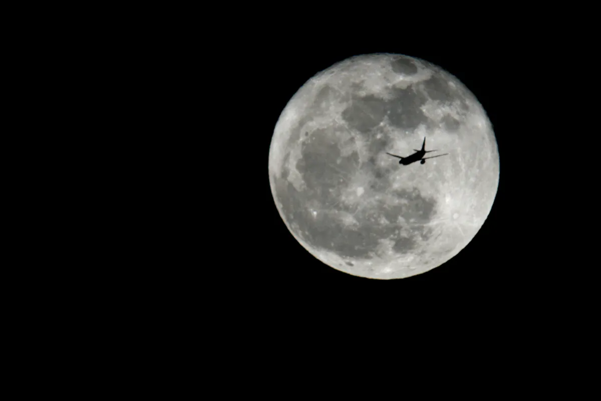 Airliner Crossing the Nearly Full Moon by Ray Bonner, London, UK. Equipment: Canon EOS 400D, Vivitar 500mm lens, x2 teleconverter
