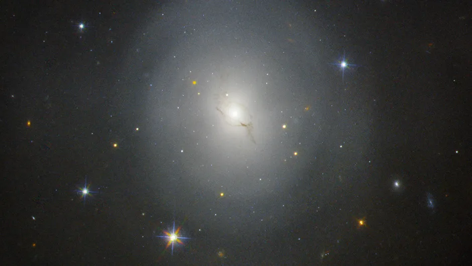 The lenticular galaxy NGC 4993, about 130 million lightyears from Earth. On 17 August 2017, gravitational waves were detected as a result of the collision of two neutron stars within this galaxy. The event resulted in a flare of light, called a kilonova, which can be seen to the upper left of the galactic centre in this Hubble Space Telescope image. Credit: NASA and ESA