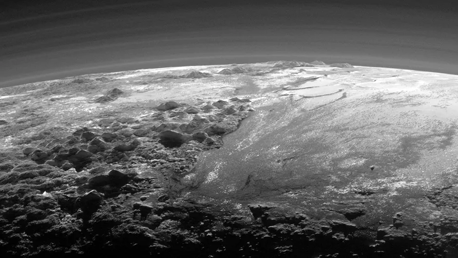 Just 15 minutes after its closest approach to Pluto on July 14, 2015, NASA's New Horizons spacecraft looked back toward the sun and captured a near-sunset view of the rugged, icy mountains and flat ice plains extending to Pluto's horizon. The smooth expanse of the informally named Sputnik Planum (right) is flanked to the west (left) by rugged mountains up to 11,000 feet (3,500 meters) high, including the informally named Norgay Montes in the foreground and Hillary Montes on the skyline. The backlighting highlights more than a dozen layers of haze in Pluto's tenuous but distended atmosphere. The image was taken from a distance of 11,000 miles (18,000 kilometers) to Pluto; the scene is 230 miles (380 kilometers) across. Image Credit: NASA/Johns Hopkins University Applied Physics Laboratory/Southwest Research Institute