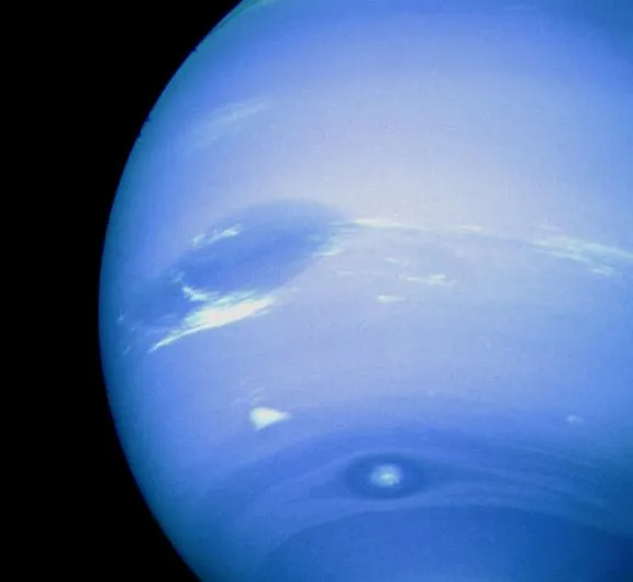 Voyager 2 photograph of Neptune. The Great Dark Spot is dominant close to the left limb, while immediately below it is a white feature nicknamed ‘Scooter’. Near the bottom of the planet's disc is Dark Spot 2, with its light core. These features are rarely seen in close proximity due to their different rotational speeds. (Credit: NASA/JPL)