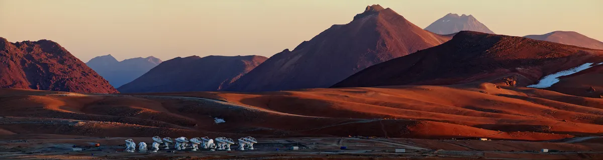 This panoramic view of the Chajnantor Plateau shows the site of the Atacama Large Millimeter/submillimeter Array (ALMA), taken from near the peak of Cerro Chico. Babak Tafreshi, an ESO Photo Ambassador, has succeeded in capturing the feeling of solitude experienced at the ALMA site, 5000 metres above sea level in the Chilean Andes. Light and shadow paint the landscape, enhancing the otherworldly appearance of the terrain. In the foreground of the image, clustered ALMA antennas look like a crowd of strange, robotic visitors to the plateau. When the telescope is completed in 2013, there will be a total of 66 such antennas in the array, operating together. ALMA is already revolutionising how astronomers study the Universe at millimetre and submillimetre wavelengths. Even with a partial array of antennas, ALMA is more powerful than any previous telescope at these wavelengths, giving astronomers an unprecedented capability to study the cool Universe — molecular gas and dust as well as the relic radiation of the Big Bang. ALMA studies the building blocks of stars, planetary systems, galaxies, and life itself. By providing scientists with detailed images of stars and planets being born in gas clouds near the Solar System, and detecting distant galaxies forming at the edge of the observable Universe, which we see as they were roughly ten billion years ago, it will let astronomers address some of the deepest questions of our cosmic origins. ALMA, an international astronomy facility, is a partnership of Europe, North America and East Asia in cooperation with the Republic of Chile. ALMA construction and operations are led on behalf of Europe by ESO, on behalf of North America by the National Radio Astronomy Observatory (NRAO), and on behalf of East Asia by the National Astronomical Observatory of Japan (NAOJ). The Joint ALMA Observatory (JAO) provides the unified leadership and management of the construction, commissioning and operation of ALMA. Links More about ALMA at ESO