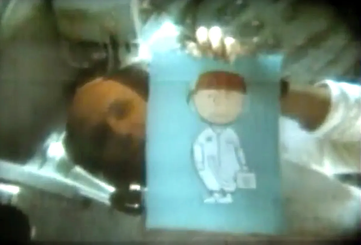 Þ Thomas Stafford holds up a picture of Charlie Brown in a spacesuit to the camera during a TV transmission. Credit: NASA