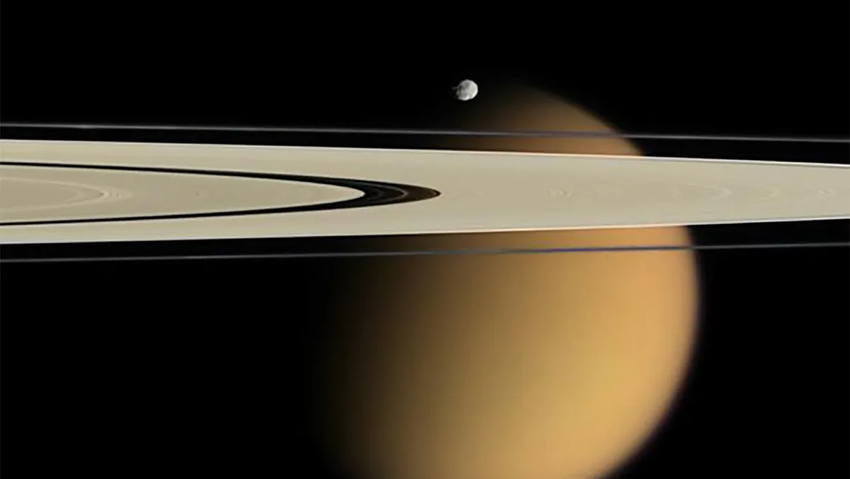 A Cassini image showing Titan, Saturn’s largest moon, behind the planet’s rings. The smaller moon Epimetheus can be seen in the foreground. Image Credit: NASA/JPL/Space Science Institute