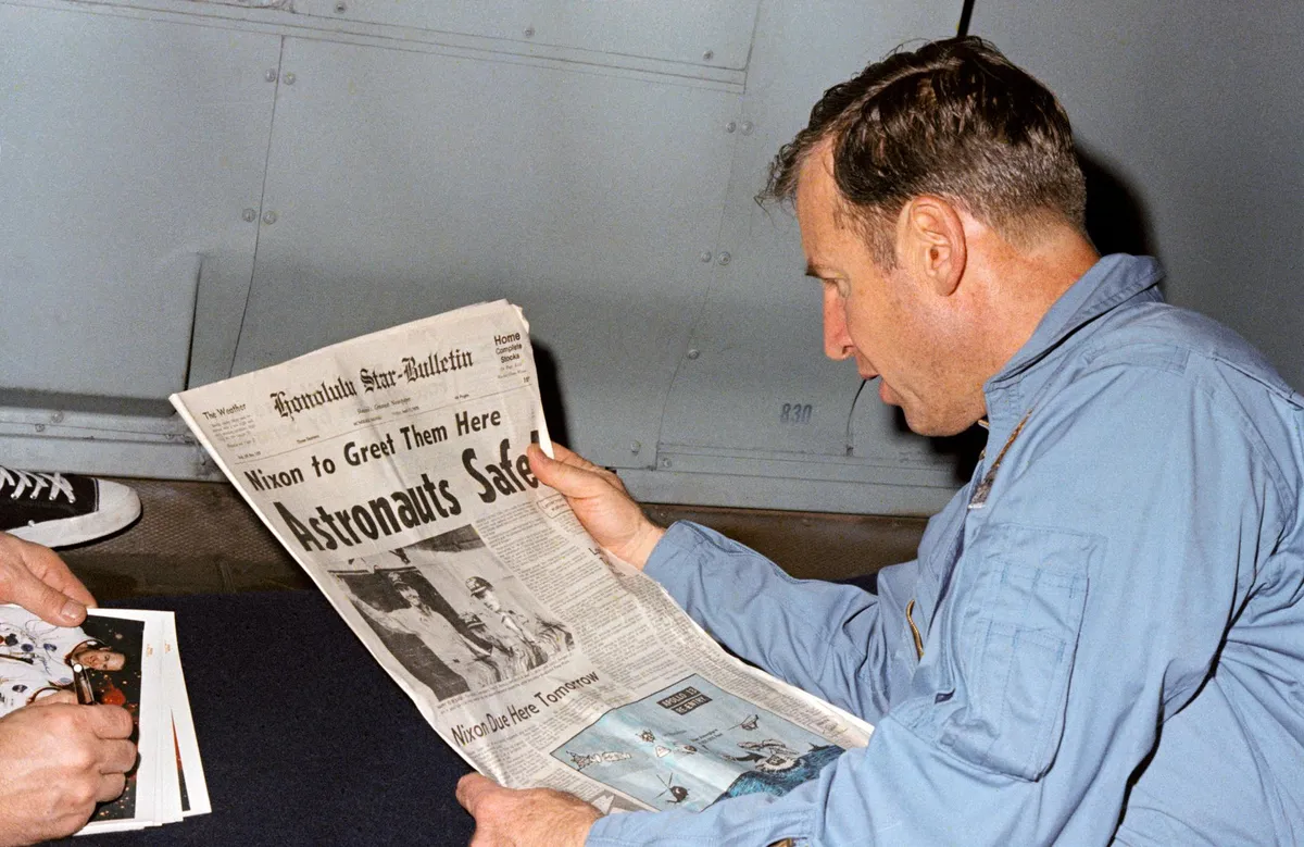 Read all about it,17 April 1970. Astronaut James A Lovell Jr, Apollo 13 mission commander, reads a newspaper article about the safe recovery of the problem-plagued mission. Credit: NASA