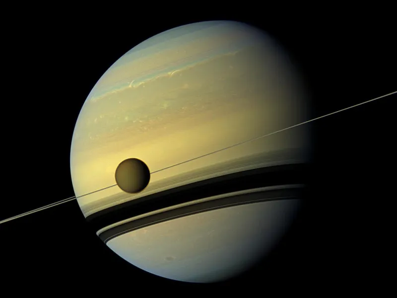 Moon Titan appears in front of Saturn in an image captured by NASA’s Cassini spacecraft. Credit: NASA/JPL-Caltech/Space Science Institute